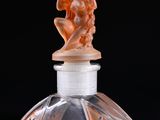 an old fashioned perfume bottle with a statue on top of it