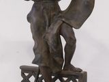 bronze statue of a woman with a basket on a pedestal