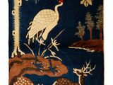 un tapis bleu orné d'oiseaux et de cerfs