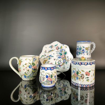 three cups and a teapot sitting on a table