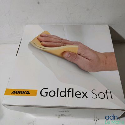 Quelqu'un nettoie une boîte de « Goldflex Soft » avec un chiffon.