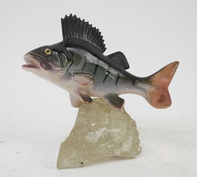 figurine of a fish on a rock on a white background