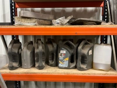 many bottles of motor oil on a shelf in a garage