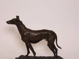 bronze statue of a dog on a black marble base