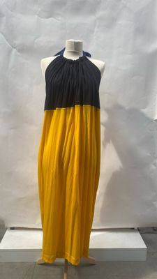 yellow and black dress on a mannequin stand in front of a white backdrop