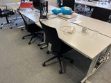 a white table with black chairs and a computer on it