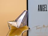 an angel perfume bottle next to a box with a star on it
