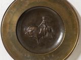 a bronze plate with a horse and rider on it