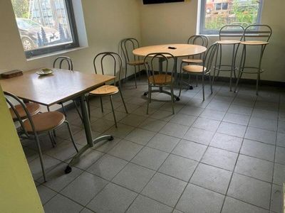 tables and chairs in a room with a television on the wall