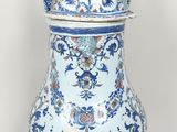 un vieux vase bleu et blanc orné d'un nœud sur le dessus