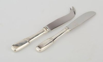 pair of silverplated cheese knives and a knife on a white surface