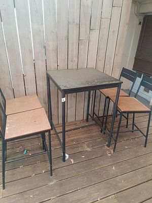 three chairs and a table on a wooden deck