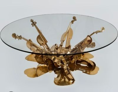 une table en verre sur laquelle se trouve un objet en métal doré