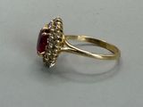 an image of a gold ring with a ruby stone and diamonds