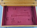 a wooden box with tools in it on a blue surface