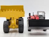 two toy trucks that are next to each other on a white surface