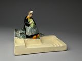 a figurine of a woman holding a baby on a tray