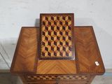 a small wooden table with a chess board on top of it