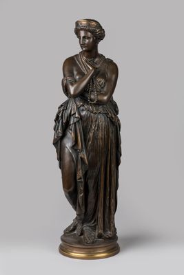 a bronze statue of a woman holding a bird on a pedestal