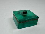 une boîte verte contenant une pomme noire