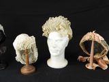 trois chapeaux et un porte-chapeaux sur fond noir