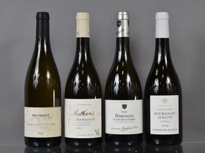 four bottles of wine are lined up on a glass table