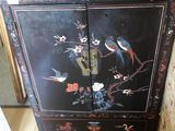 une armoire noire décorée de fleurs et d'oiseaux peints