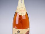 Des bouteilles de vin sont posées sur une surface blanche, sur fond gris.