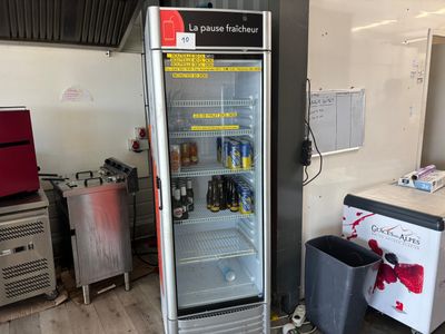 une photo d'un réfrigérateur dans une cuisine, avec une poubelle à côté