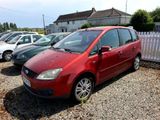 a red car parked in a parking lot next to other cars