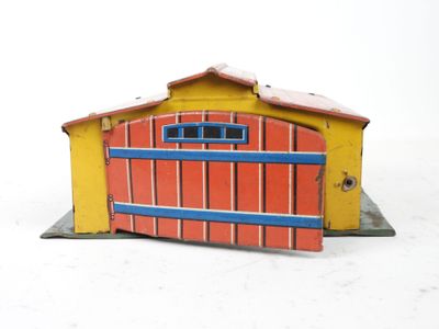 un petit bâtiment jaune et rouge avec une porte bleue
