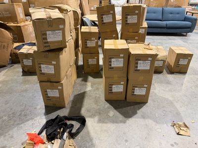 une pile de cartons et une paire de ciseaux par terre