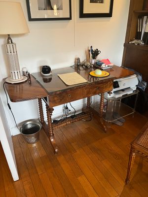 a desk with a chair and a lamp in a room