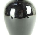 a black vase that is sitting on a white surface