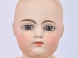 a close up of a doll with a sweater on