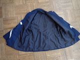 a black jacket on the floor with a white stripe