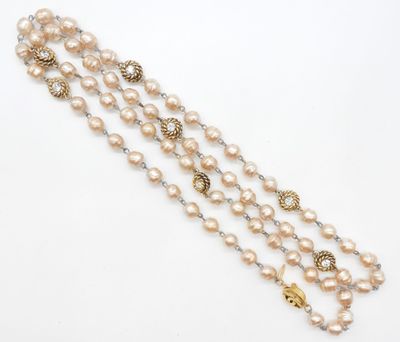 un gros plan sur un collier composé de perles et de perles en or