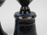 two black vases sitting next to each other on a table