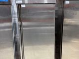 three stainless steel refrigerators are lined up in a warehouse