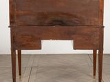 an old wooden desk with a drawer underneath it on a tiled floor
