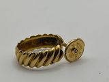 a close up of a gold ring with a button on it