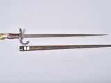 two old swords are laying side by side on a white surface