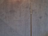a lamp on a wooden floor in front of a gray wall