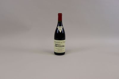 une bouteille de vin posée sur une surface blanche