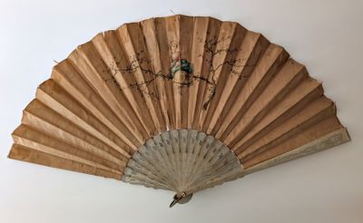 un ventilateur accroché au mur, sur lequel est posé un oiseau