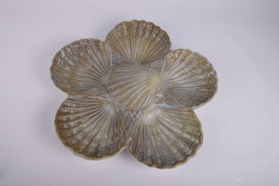 un objet en forme de coquillage posé sur une surface blanche