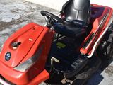 a red lawn mower parked on the side of the road