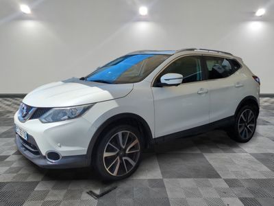 un SUV Nissan blanc garé sur un sol à damier dans un garage