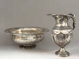 a silver vase and a silver bowl on a table