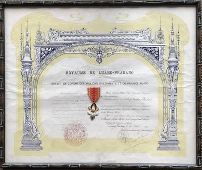 un vieux document orné d'un ruban rouge et d'une médaille